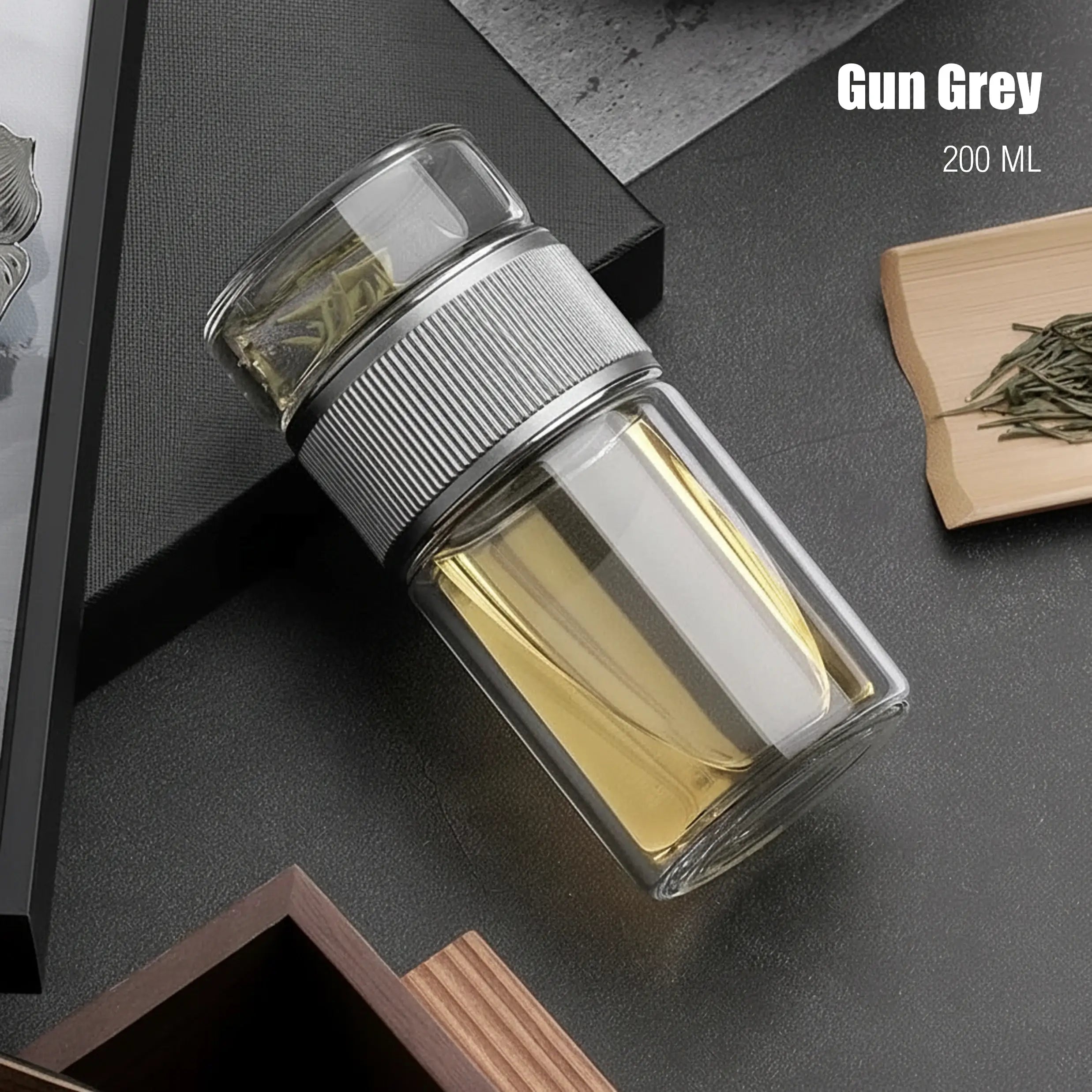 Clear glass container with metallic lid on a dark surface, labeled 'Gun Grey' and '200 ML'.