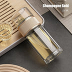 Clear glass bottle with gold cap on a dark surface, labeled 'Champagne Gold 250 ML'.