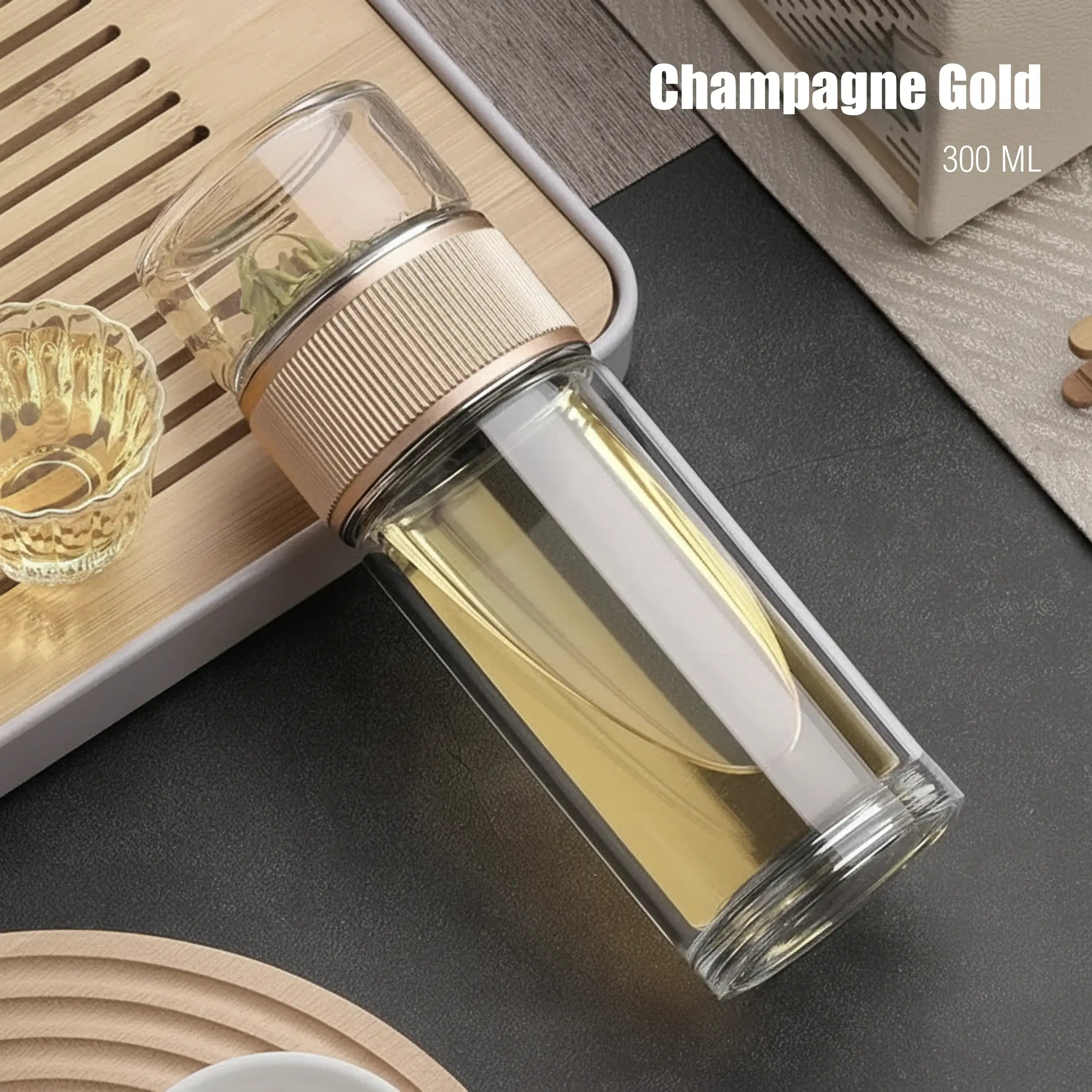 Clear glass bottle with gold cap on a dark surface, labeled 'Champagne Gold' and '300 ML'.