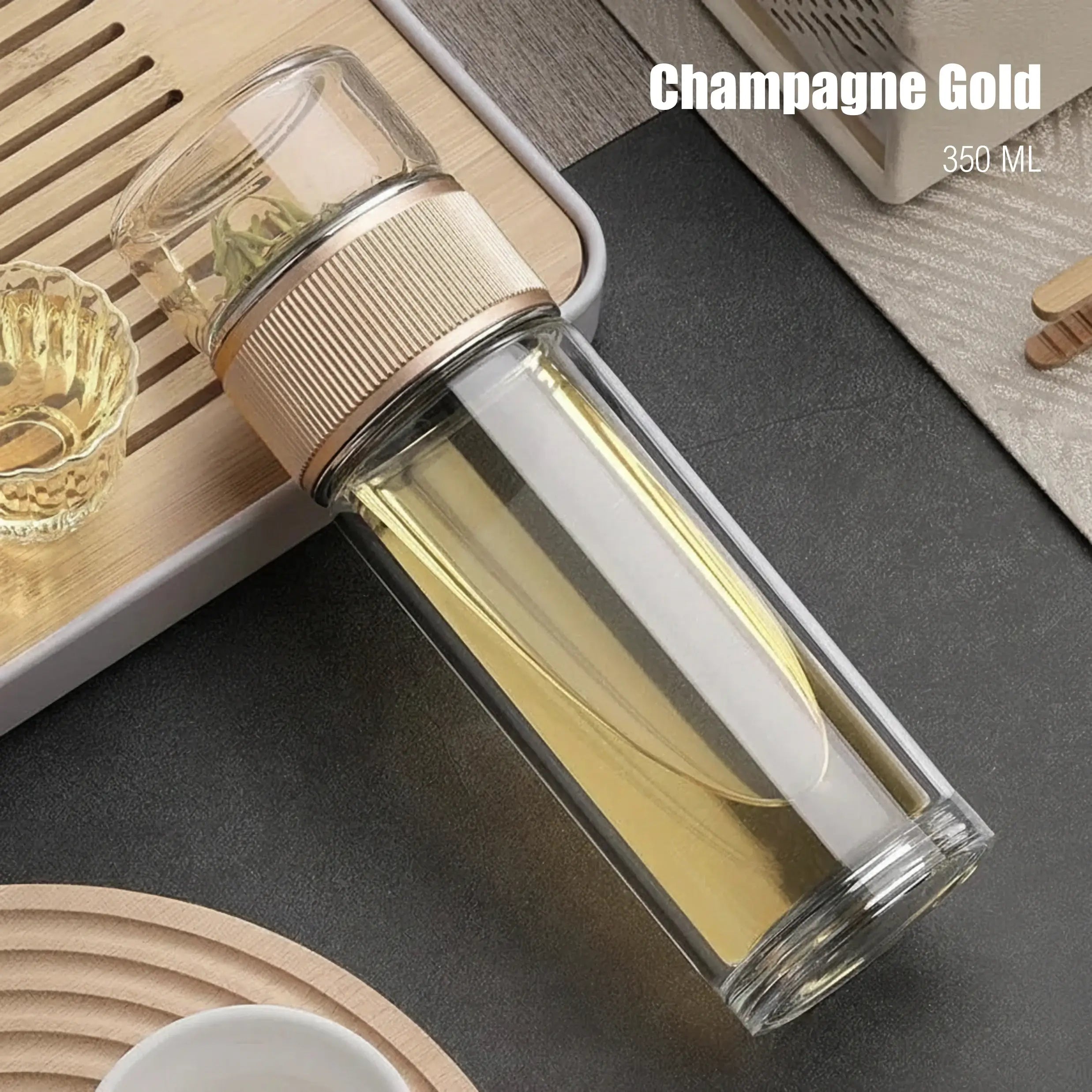 Clear glass tumbler with gold accent on a dark surface, labeled 'Champagne Gold' and '350 ML'.