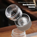 Tea infuser with glass lid and metal mesh on a wooden surface