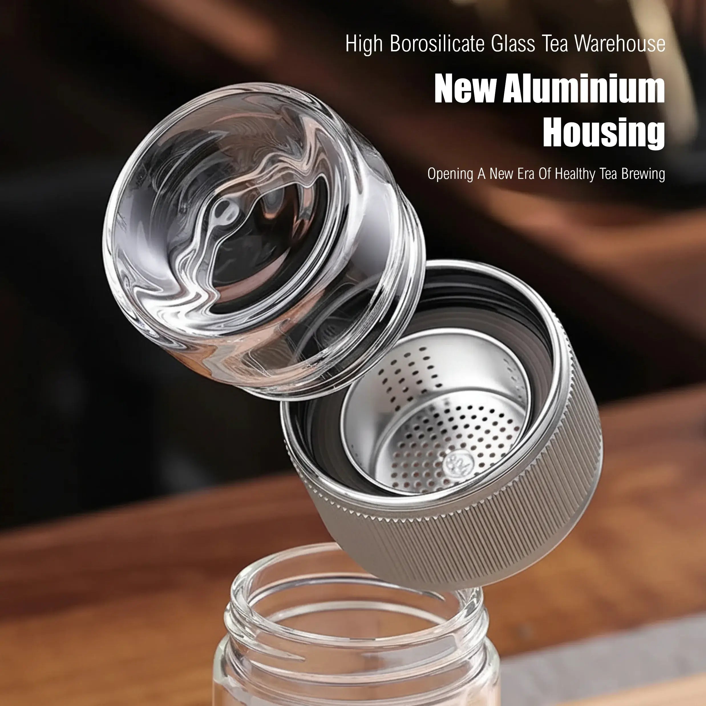 Tea infuser with glass lid and metal mesh on a wooden surface