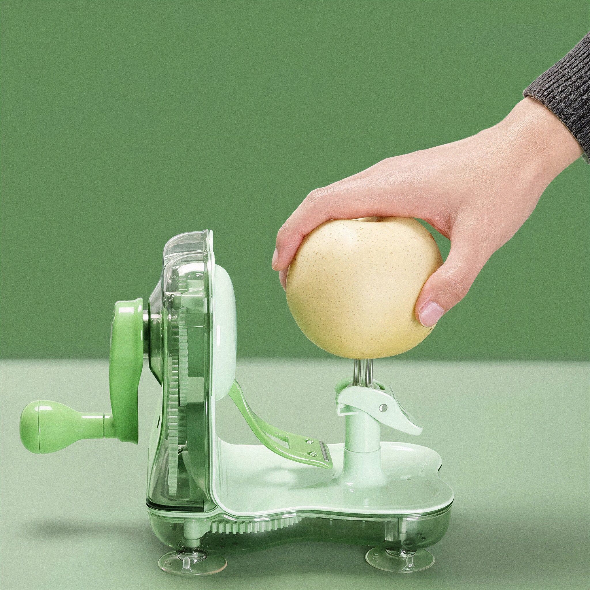 Person using a green apple peeler on a light green background