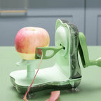 Green apple peeler with an apple being peeled on a green surface